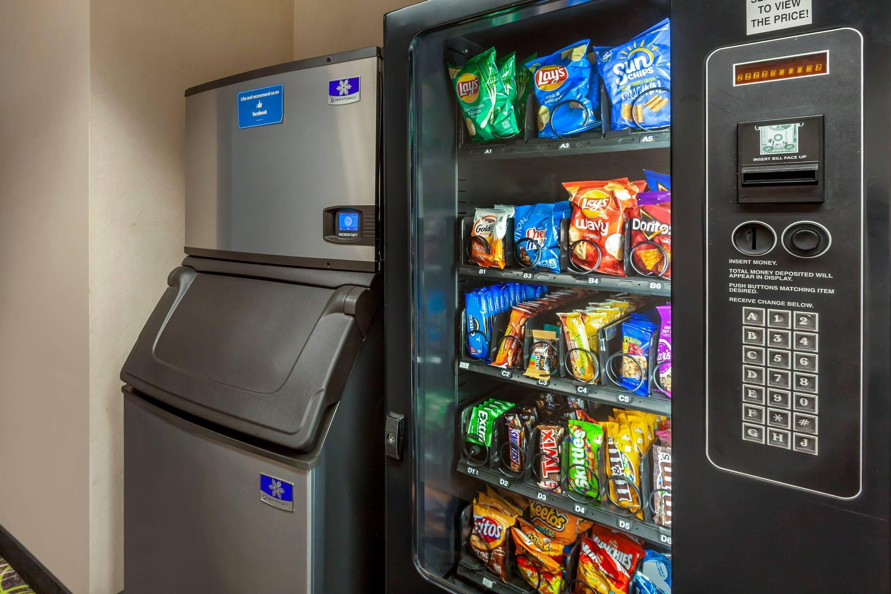 Máquina expendedora con diferentes aperitivos y un refrigerador pequeño.