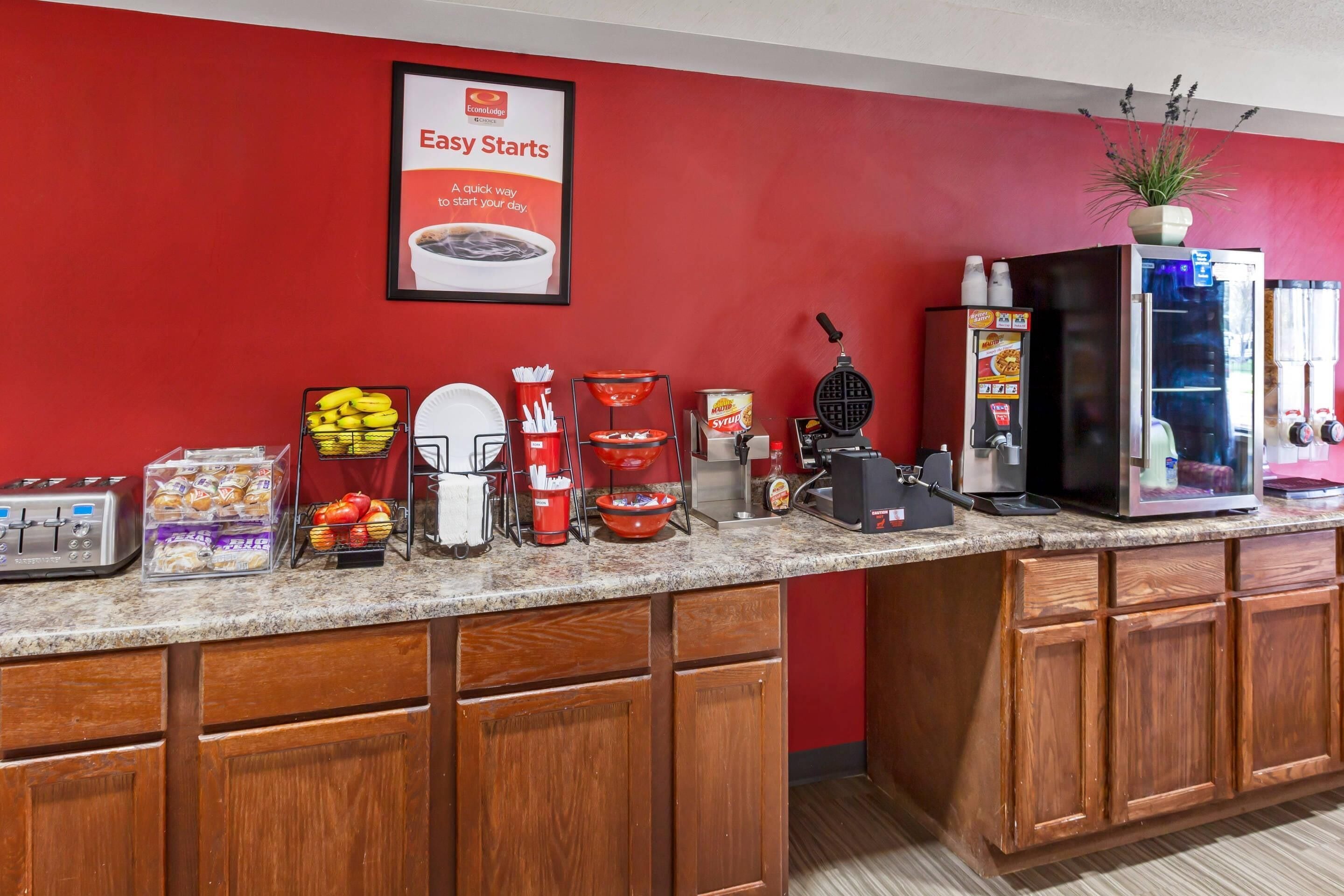 A kitchen counter with a toaster, a waffle maker, a coffee machine, and a refrigerator.
