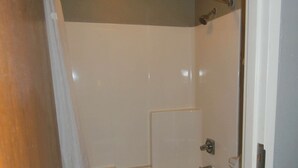 Un baño con bañera, inodoro y ducha.
