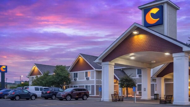 A hotel with a prominent crescent logo, covered parking, and a brick facade. - Comfort Inn Iron Mountain North (Iron Mountain)