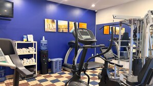 A gym with exercise equipment, a water dispenser, and a TV on the wall. - Comfort Inn Iron Mountain North (Iron Mountain)