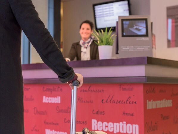 Una recepción con una persona empujando un carrito de equipaje.