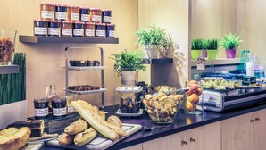 Un buffet de petit-déjeuner proposant des viennoiseries, des confitures et un assortiment de boissons.