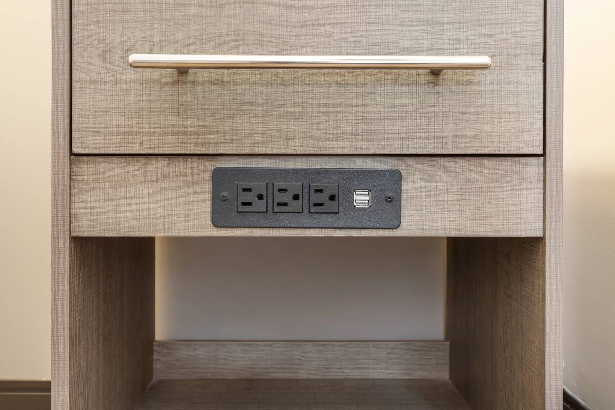 Uma gaveta com puxador, uma tomada com quatro entradas e uma porta USB.
