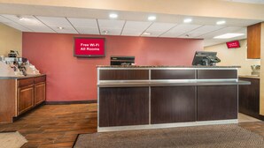 A reception area with a counter, a coffee machine, and a sign indicating free Wi-Fi in all rooms. - Red Roof Inn Virginia Beach (Virginia Beach)
