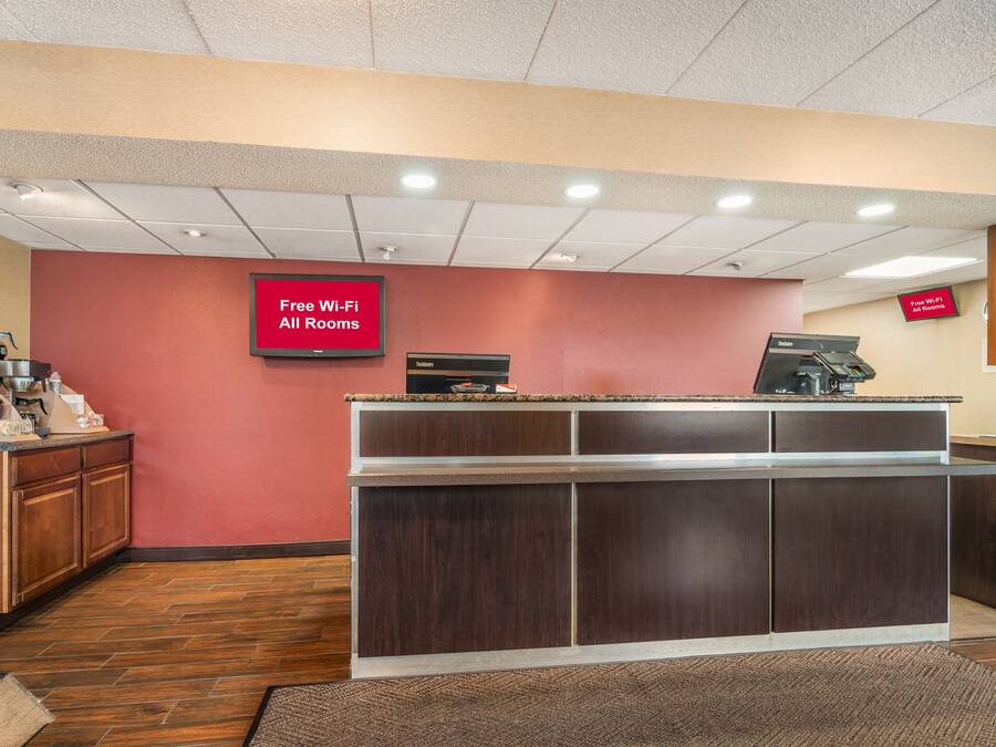A reception area with a counter, a coffee machine, and a sign indicating free Wi-Fi in all rooms.