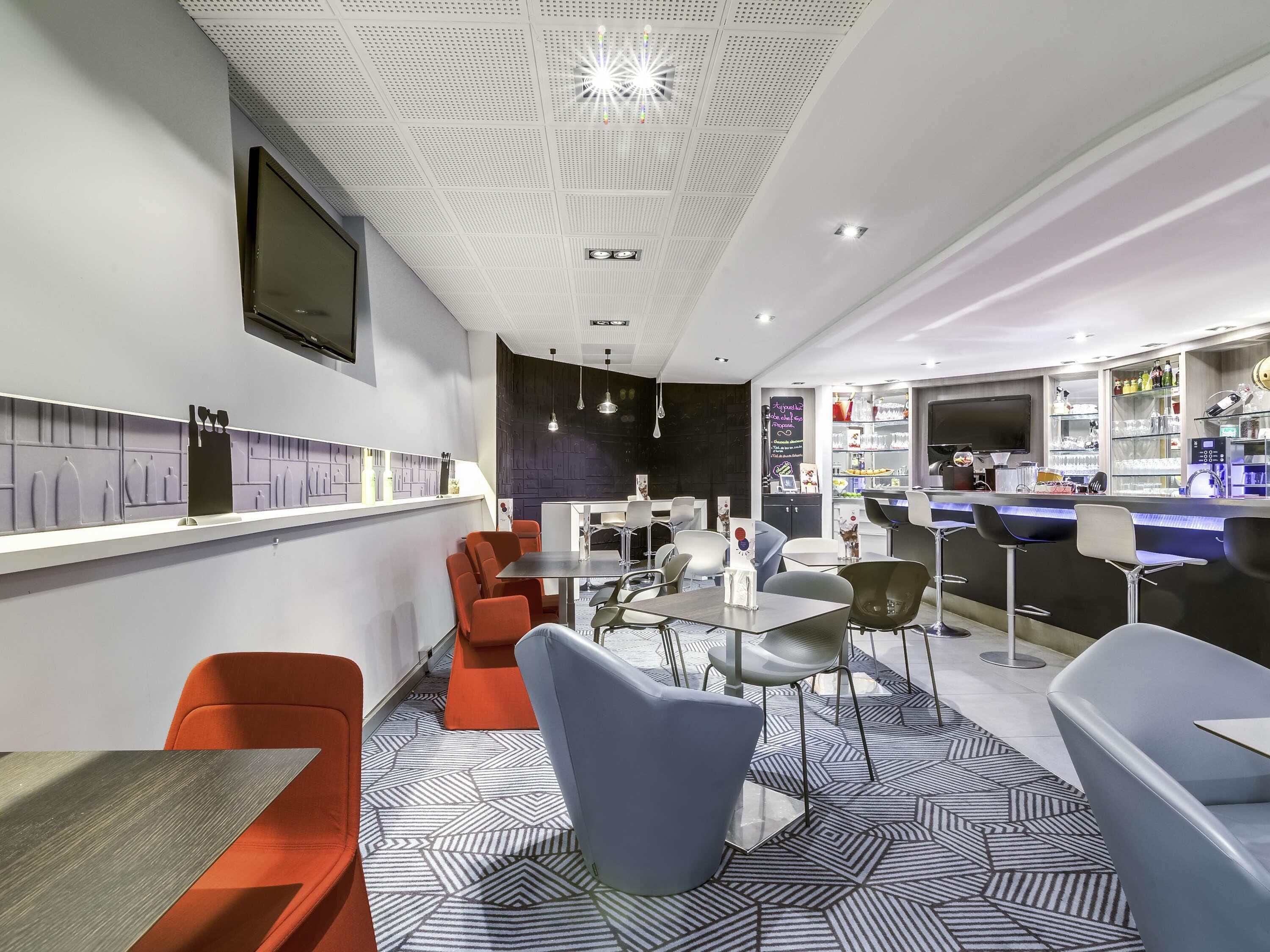 A modern bar area with seating, a counter, and a patterned floor.