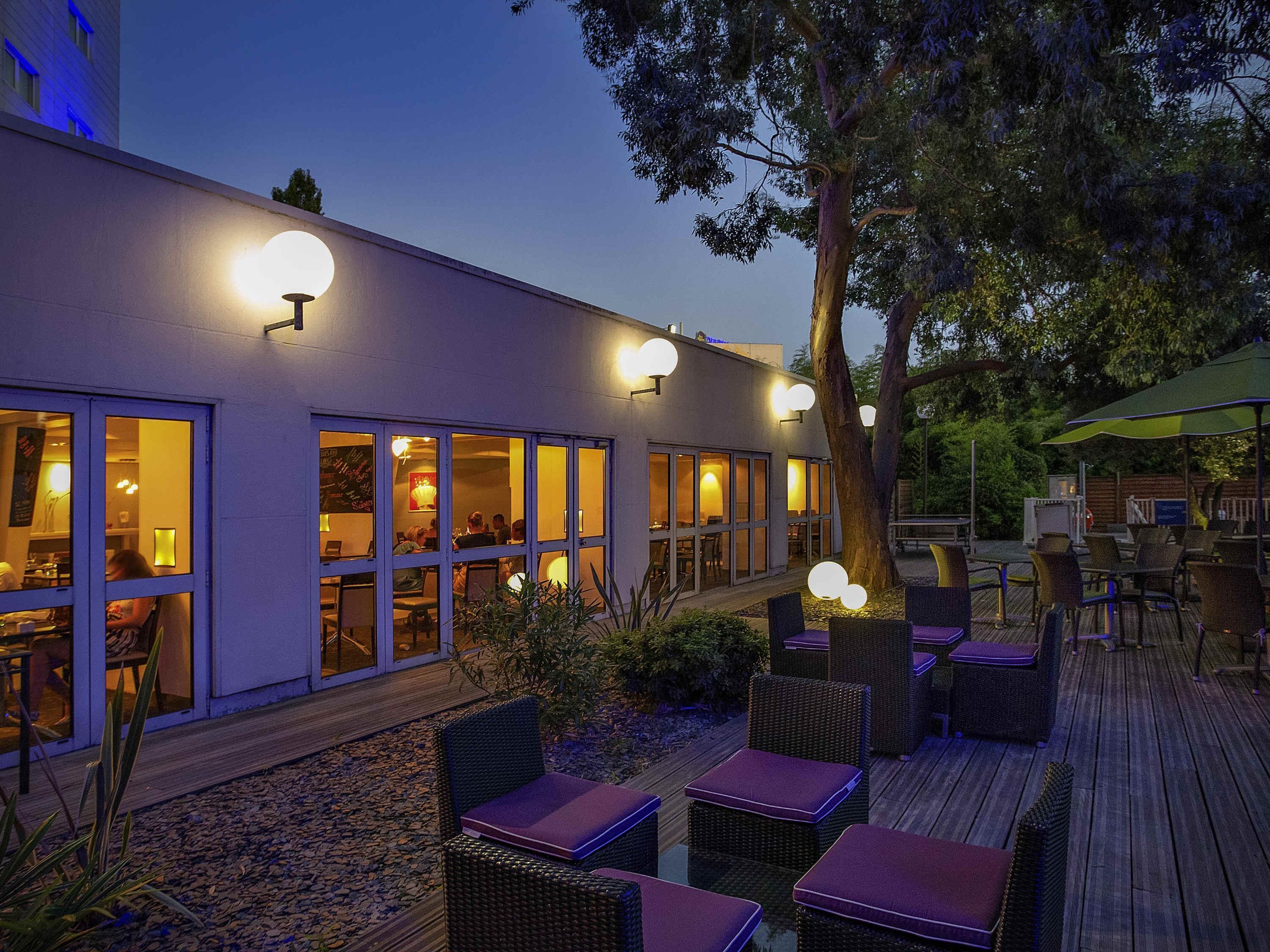 Un espacio de estar al aire libre con mobiliario de mimbre y una terraza de madera.