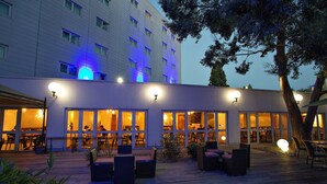 A hotel with outdoor seating and a covered patio area.