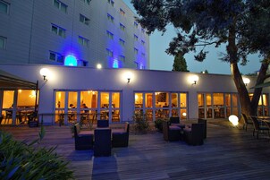 A hotel with outdoor seating and a covered patio area.