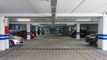 Garagem de estacionamento com vários andares e diversos carros estacionados.