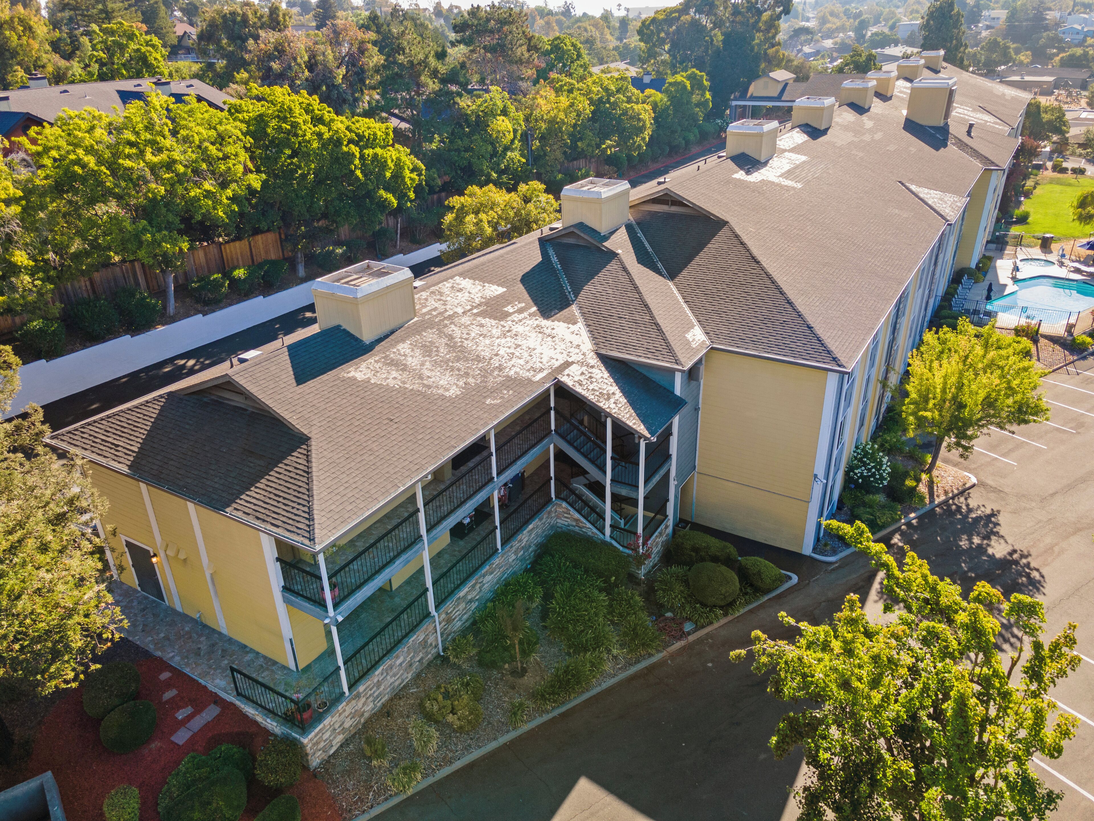 A multi-story building with a central courtyard, balconies, and a swimming pool.
