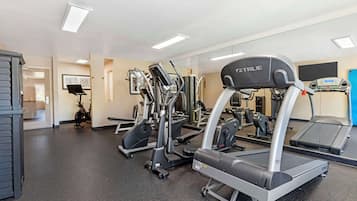 A gym with treadmills, elliptical machines, and weight equipment.
