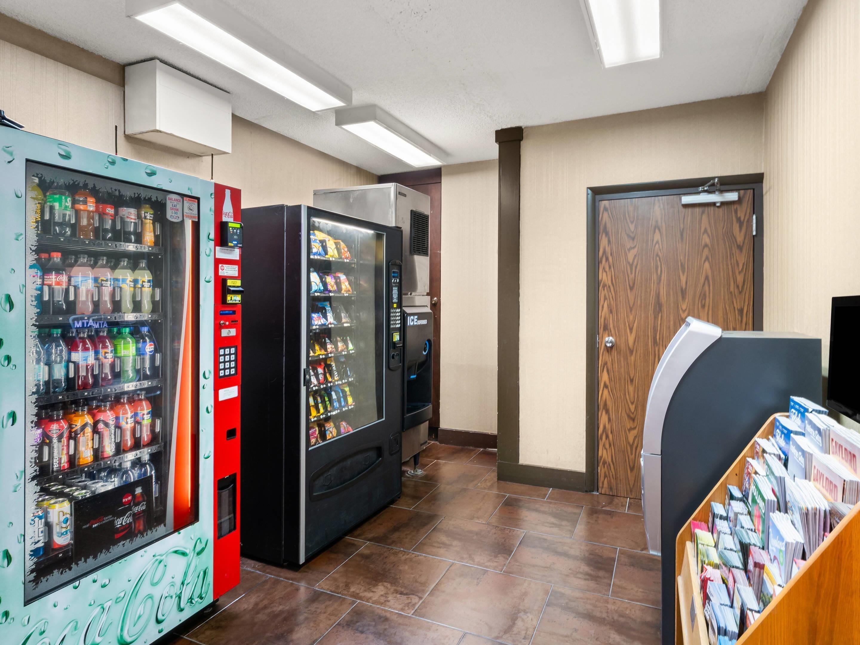 A vending area with various drink machines and a magazine rack.