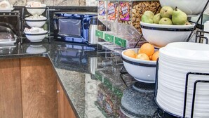 A buffet area with various food items, including cereal, fruits, and beverages. - Comfort Inn Metro Airport (Romulus)