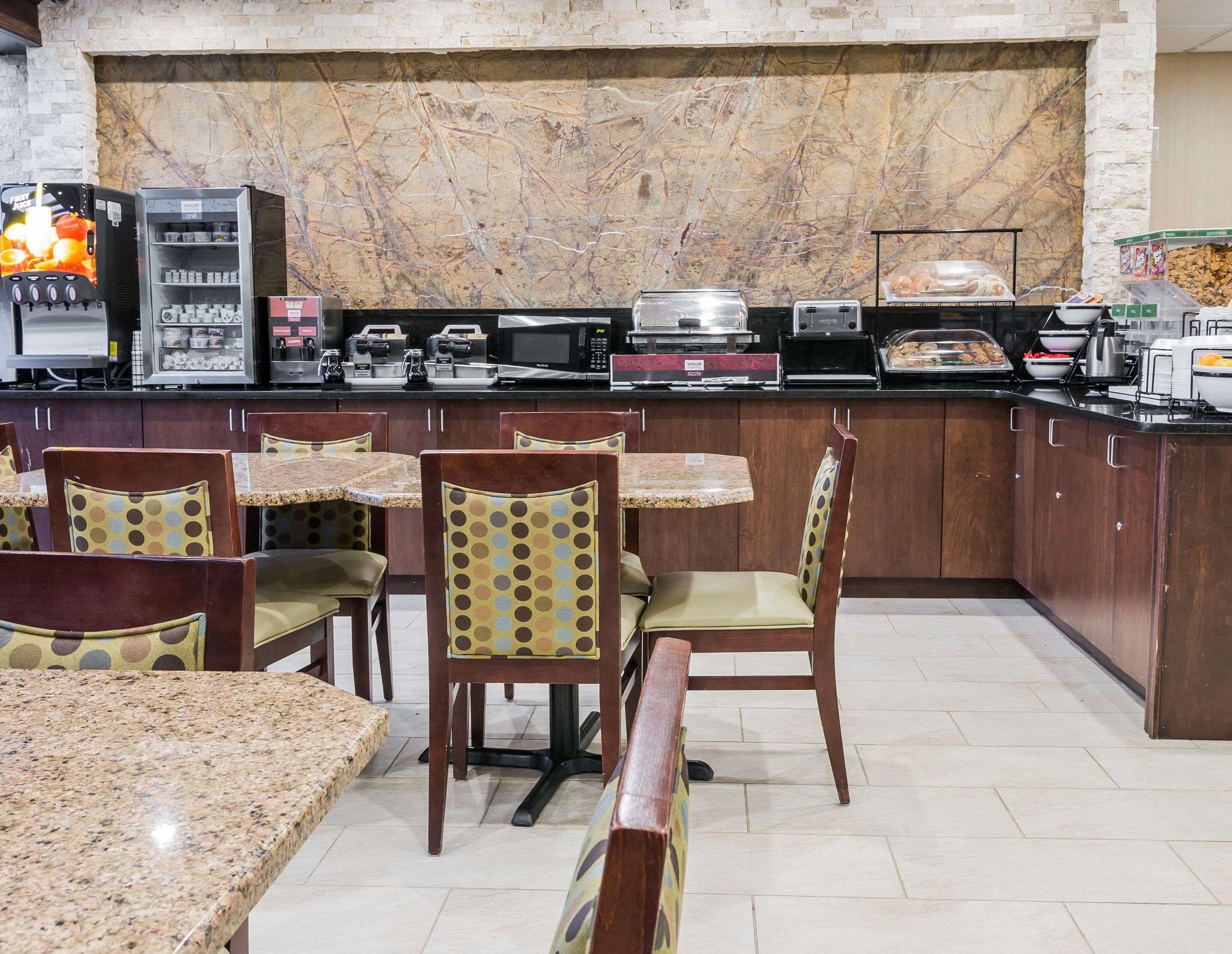 A restaurant with marble walls, granite tables, and patterned chairs.