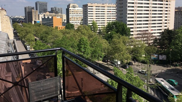 A cityscape with high-rise buildings, a street with cars, and trees. - Hotel Inn Design Paris Place d'Italie (Paris)