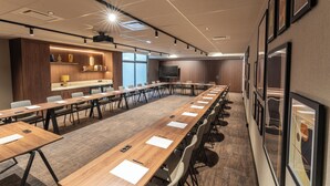 A conference room with long tables, chairs, a projector, and a large screen. - Hotel Inn Design Paris Place d'Italie (Paris)
