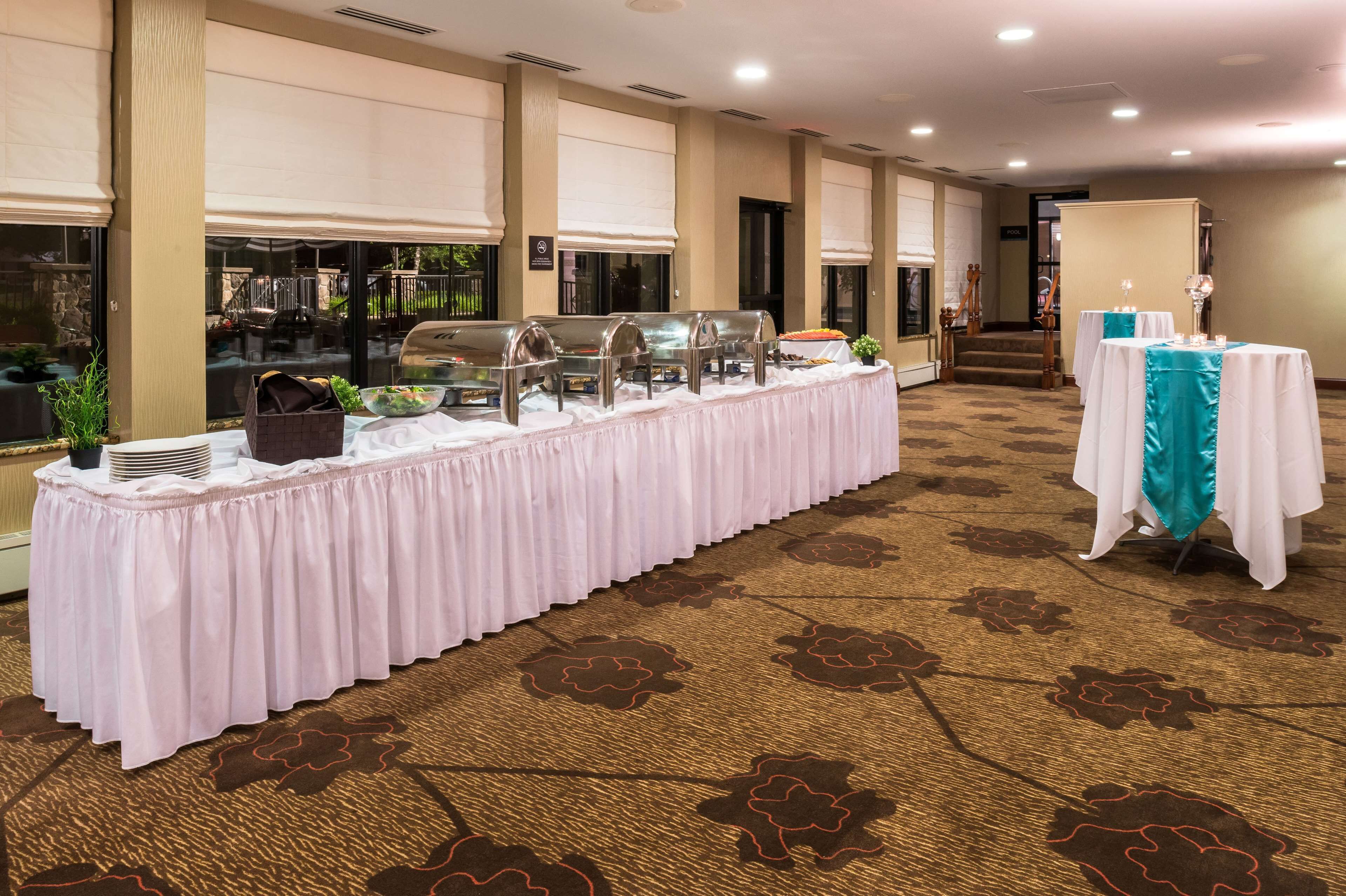A buffet setup with a long table, covered with a white tablecloth, and a teal table runner.