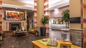 A lobby with a fireplace, seating area, and a reception desk.