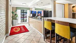 A modern kitchen with a bar area, a red doormat, and a view of the outside. - Econo Lodge Augusta North - Washington Road (Augusta)