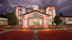 A hotel with a prominent entrance, a sign reading "Econo Lodge," and a red carpet leading to the door. - Econo Lodge Augusta North - Washington Road (Augusta)