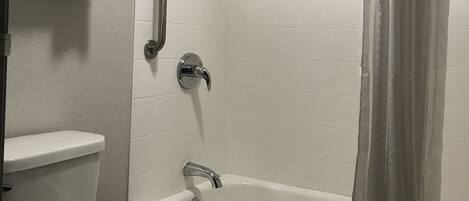 Un baño con inodoro, ducha con puerta de cristal y bañera.