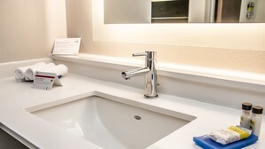 A hotel bathroom with a white sink, a mirror above it, and toiletries on the counter. - Holiday Inn Express Allentown North by IHG (Allentown)