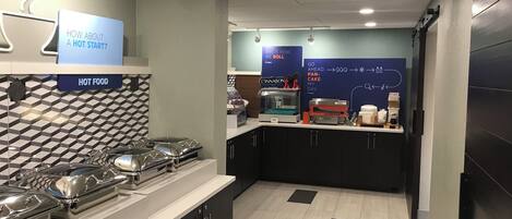 Un espace cuisine moderne avec un buffet, comprenant des récipients hermétiques pour les aliments et une machine à café.