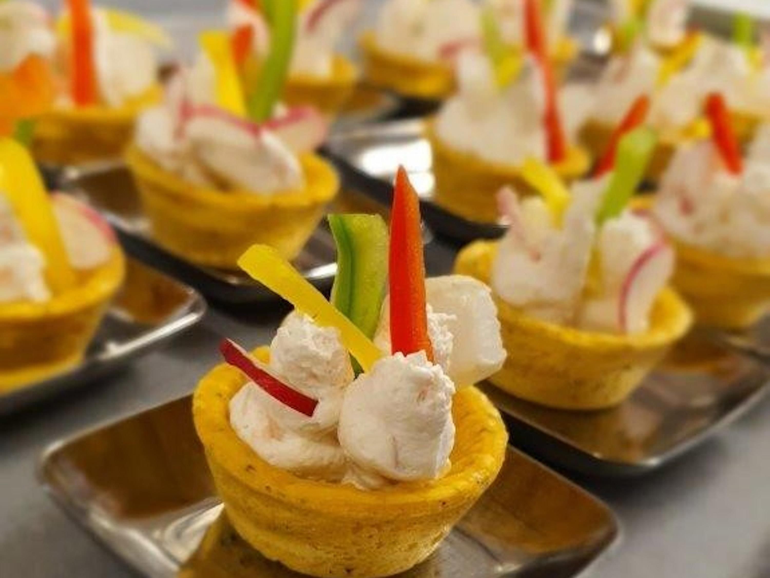 A tray of food items, possibly appetizers, arranged on a metal serving tray.
