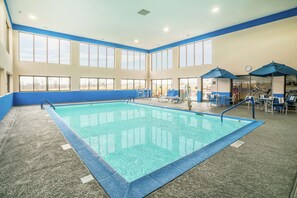 Una piscina techada, sillones reclinables de piscina