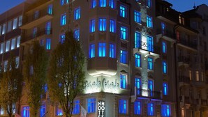 Un hotel de varios pisos con ventanas iluminadas y un cartel llamativo que dice "Hotel Cascada".