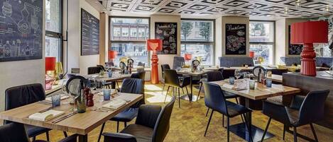 Un restaurante con varias mesas y sillas, techo decorado y amplios ventanales.