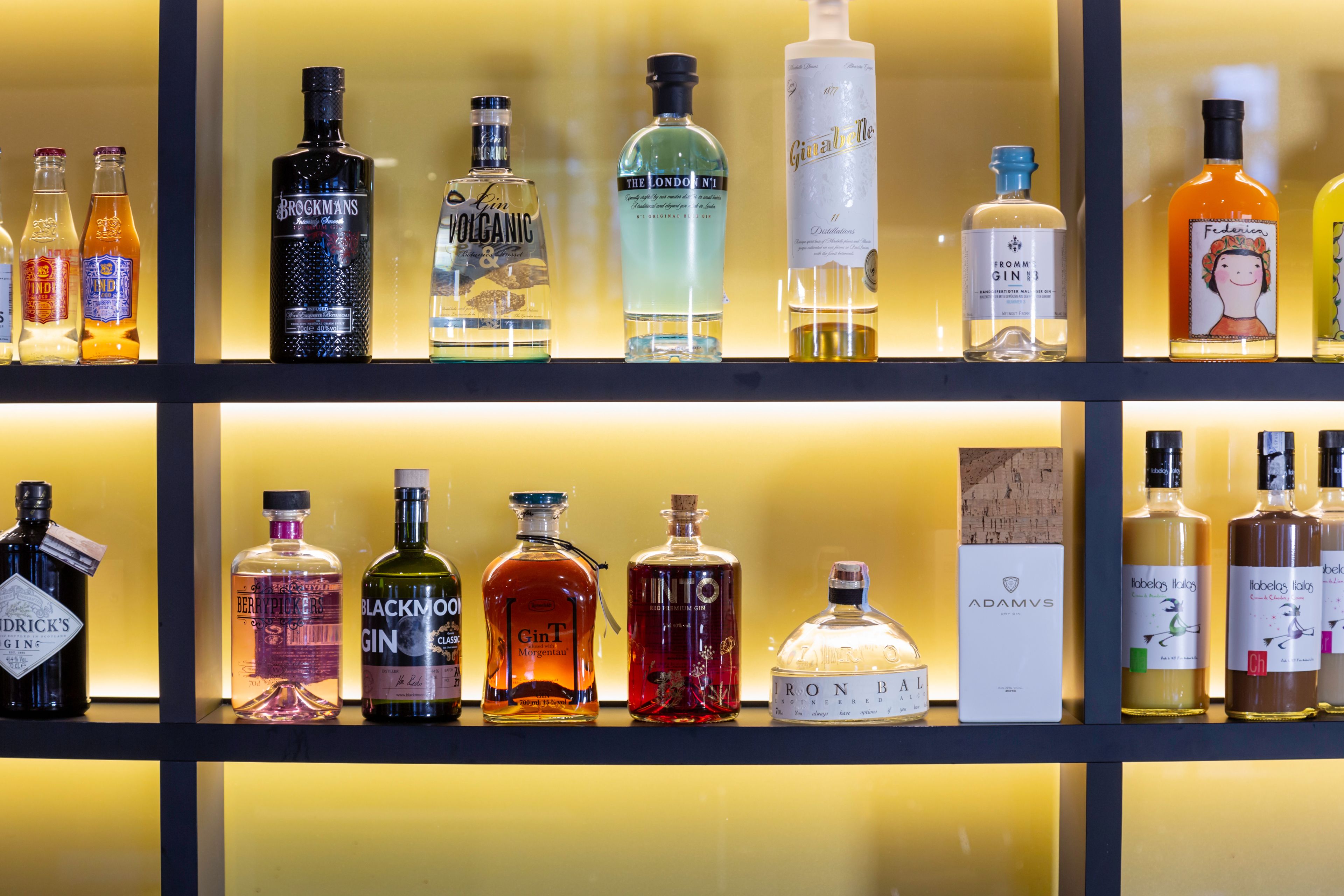 Diversas garrafas de bebidas alcoólicas expostas em prateleiras.