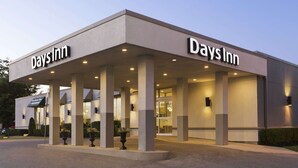 Un bâtiment de la chaîne Days Inn, caractérisé par une façade plate, de larges piliers et un espace d’entrée abrité.