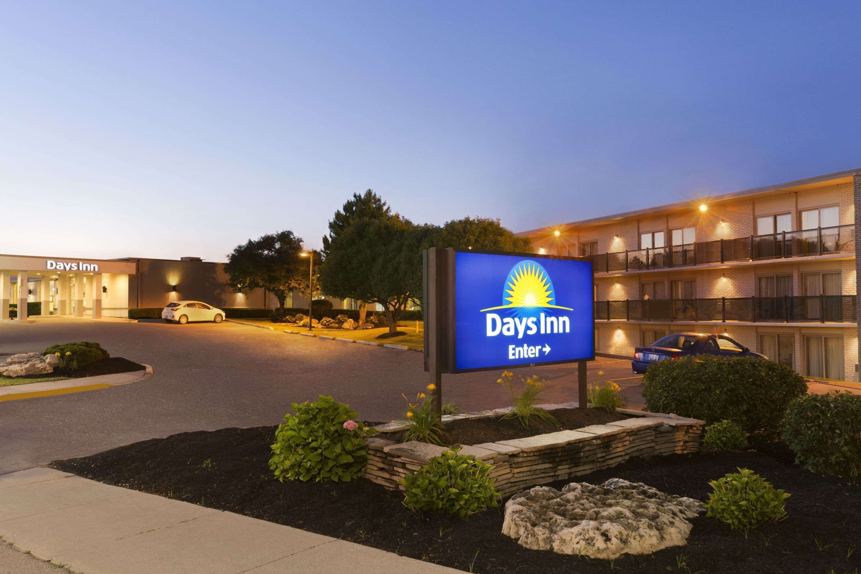 A Days Inn sign with a clear entrance and a parking lot.