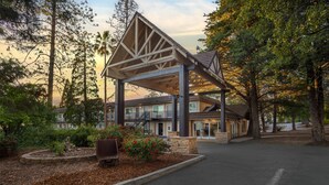 A building with a covered entrance, surrounded by trees and a landscaped garden. - Best Western Gold Country Inn (Grass Valley)