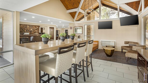 A spacious kitchen with a wooden island, bar stools, and a stone accent wall. - Best Western Gold Country Inn (Grass Valley)