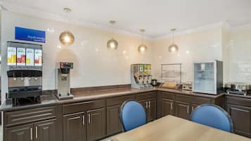 A modern kitchen with a juice bar, a refrigerator, and a microwave.