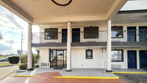 Un immeuble de deux étages doté d’une entrée abritée, de plusieurs balcons et d’un parking.