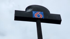 Une haute structure métallique noire, surmontée d’une enseigne bleue et rouge portant le chiffre « 6 ».