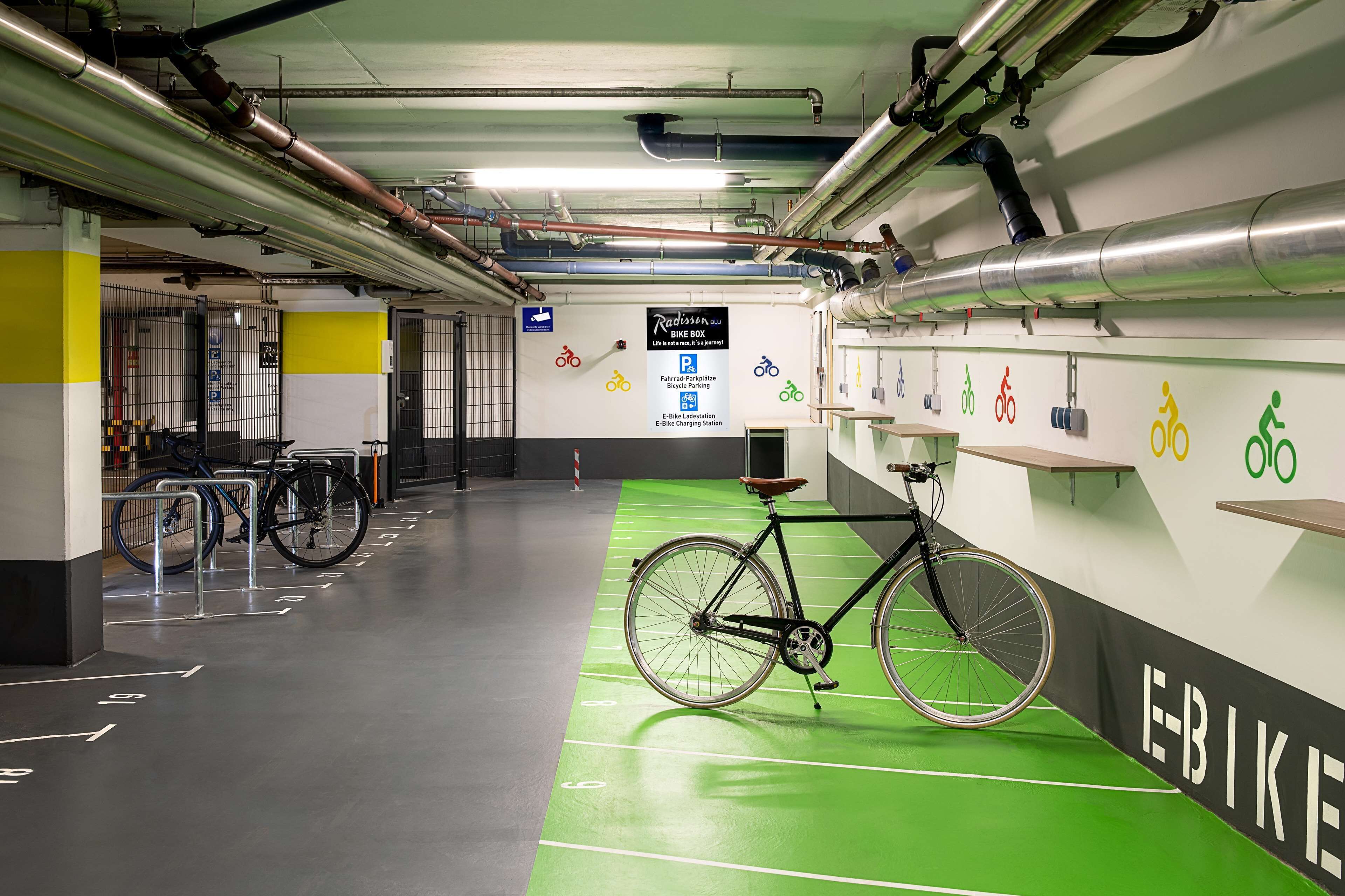 Un espace de stationnement pour vélos comprenant un local à vélos vert et un panneau indiquant si des places de stationnement sont disponibles.