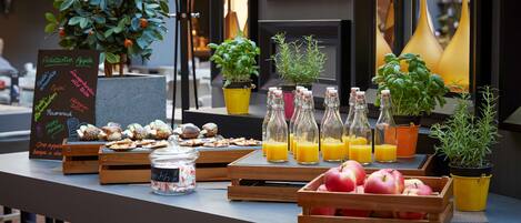 Un bufé de desayuno con diversas frutas, zumos y bollería.