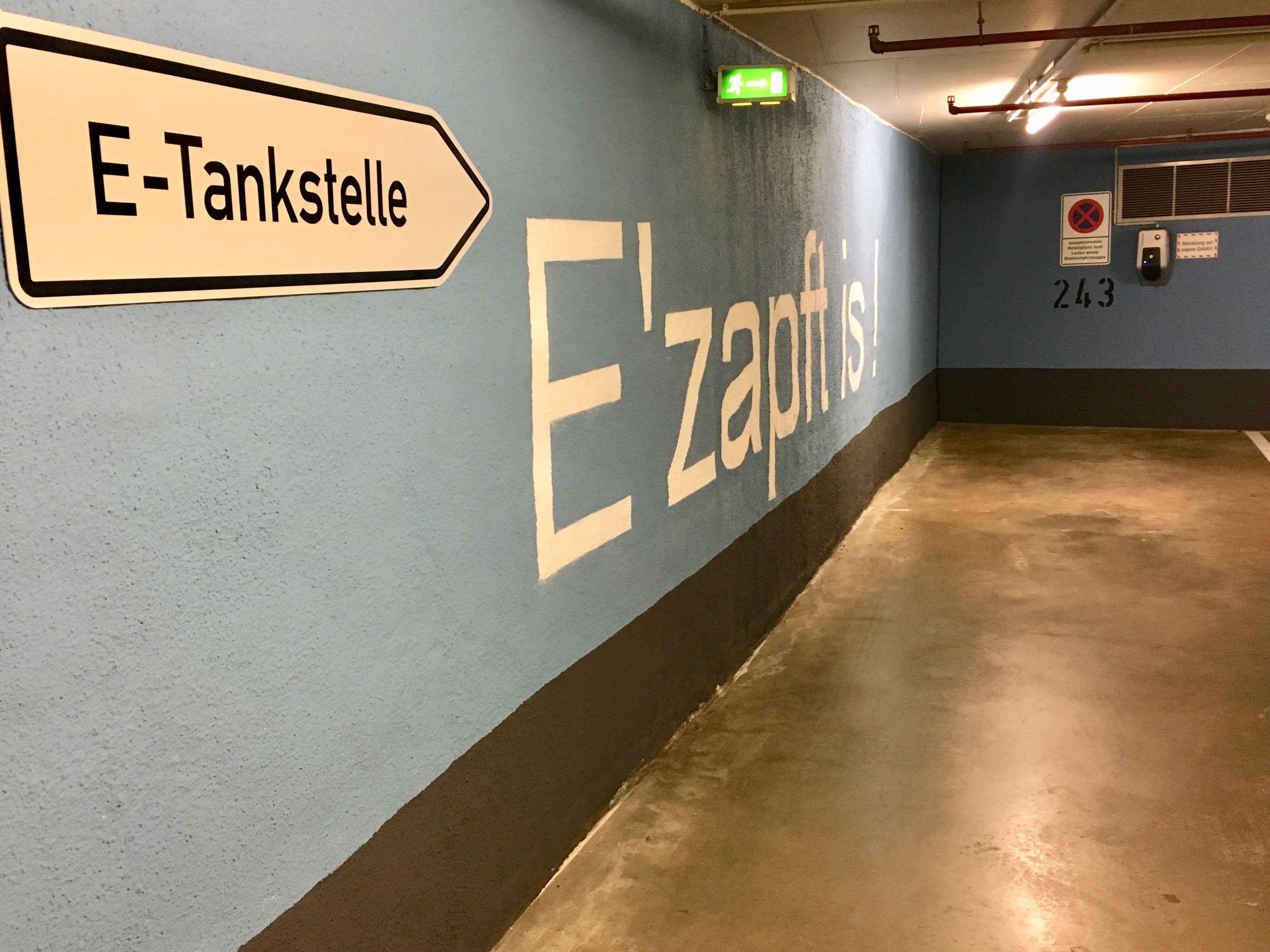 Ein Flur mit einem Schild, das „E-Tankstelle“ und „E'zapfisch“ zeigt.