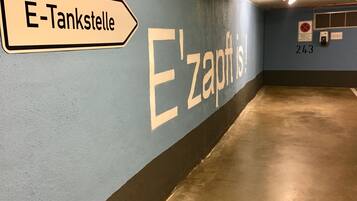 Ein Flur mit einem Schild, das „E-Tankstelle“ und „E'zapfisch“ zeigt.