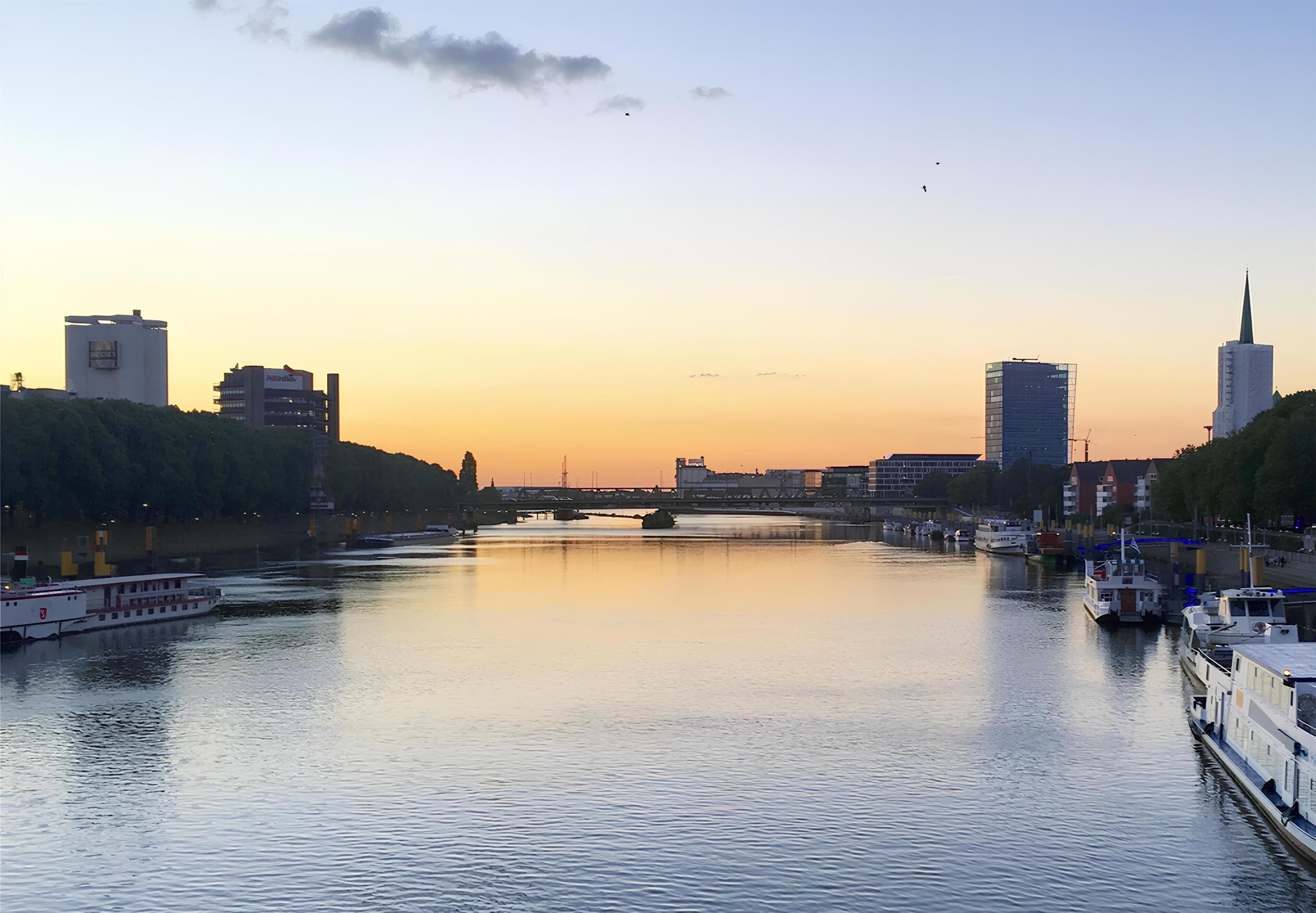 A river with boats, a bridge, and buildings along the banks.