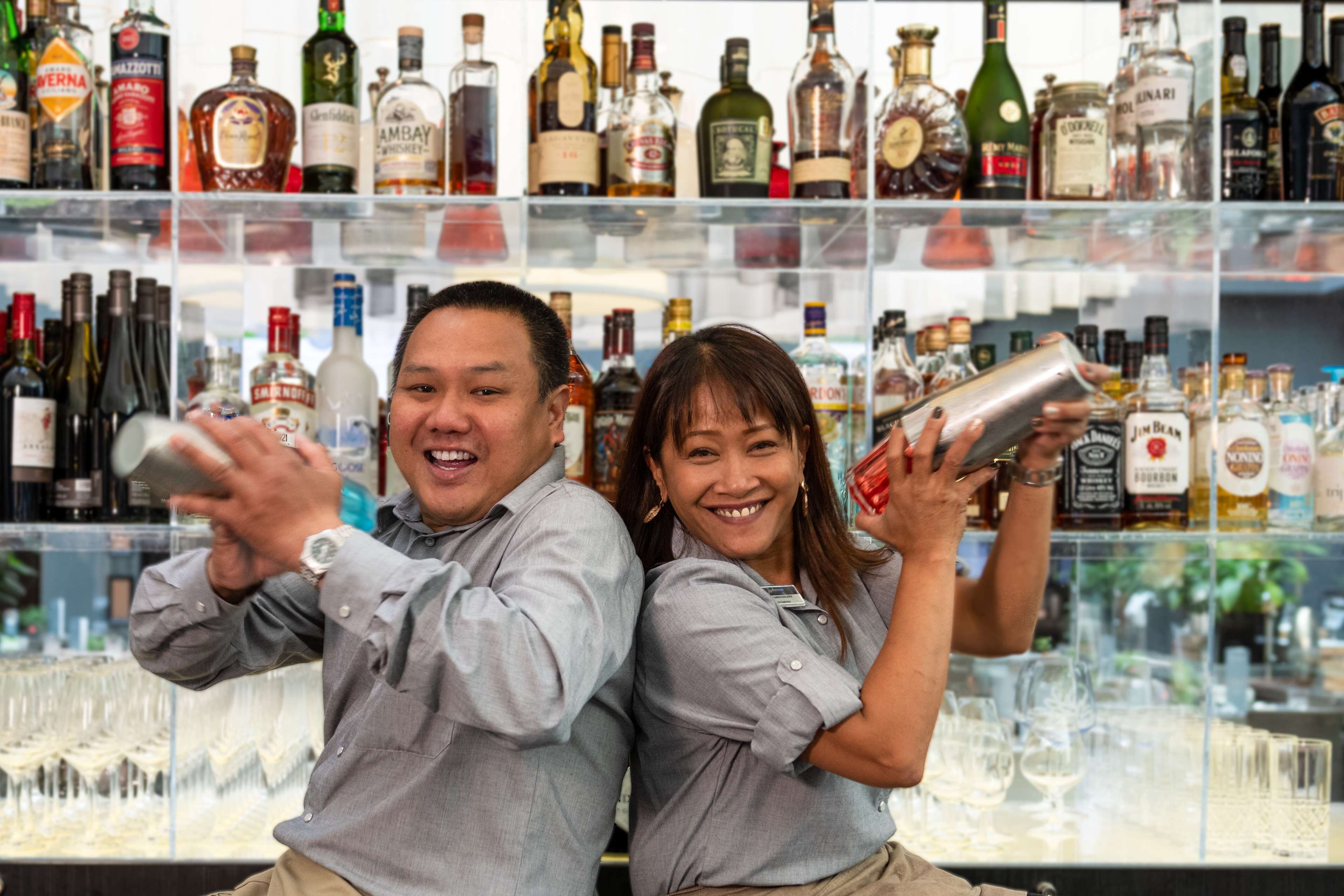 A bar with shelves of liquor bottles and glasses.