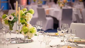 A table set for a formal event with a centerpiece of flowers and candles, surrounded by empty wine glasses and cutlery.
