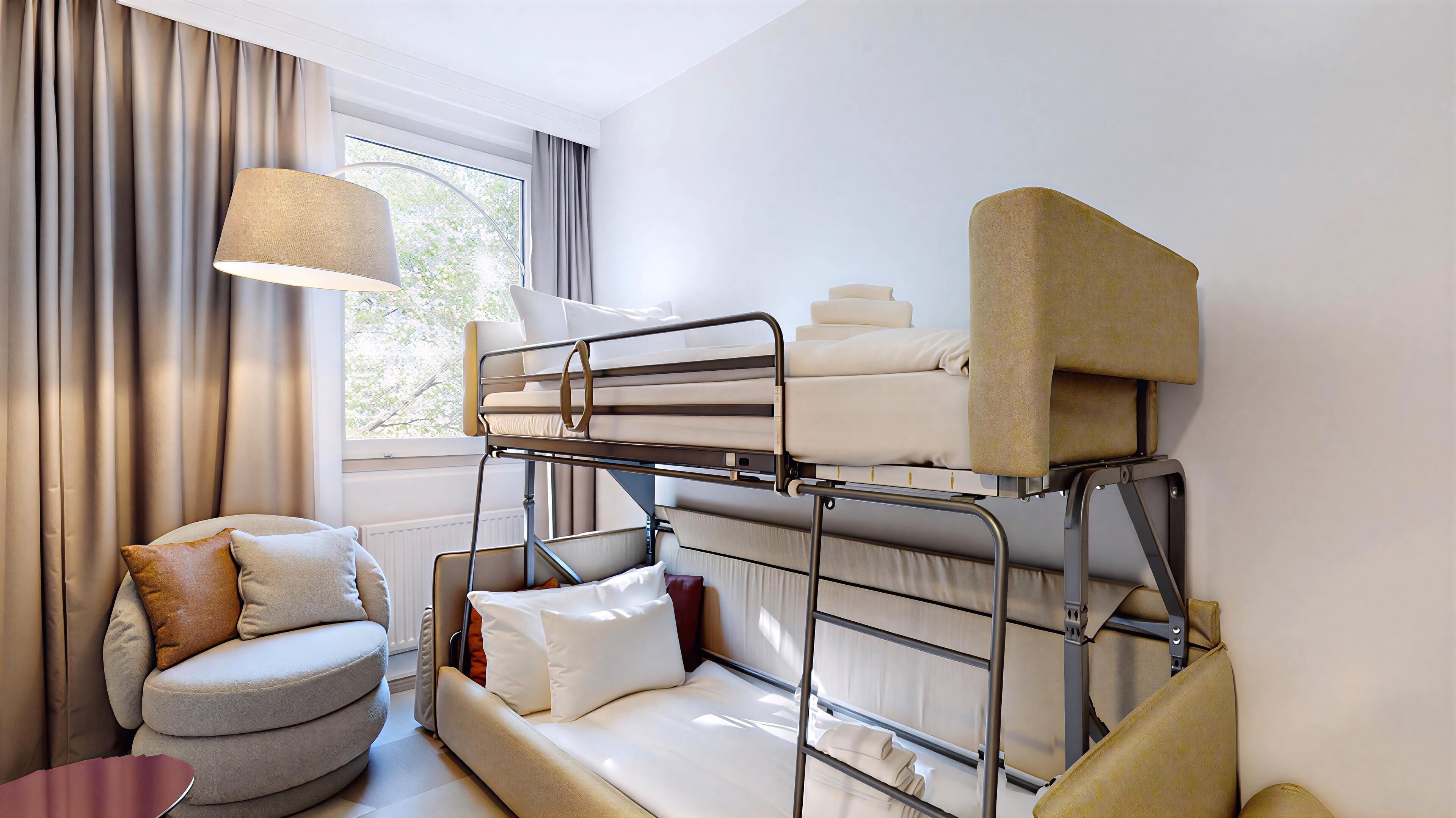 A bunk bed room with a window, a chair, and a lamp.