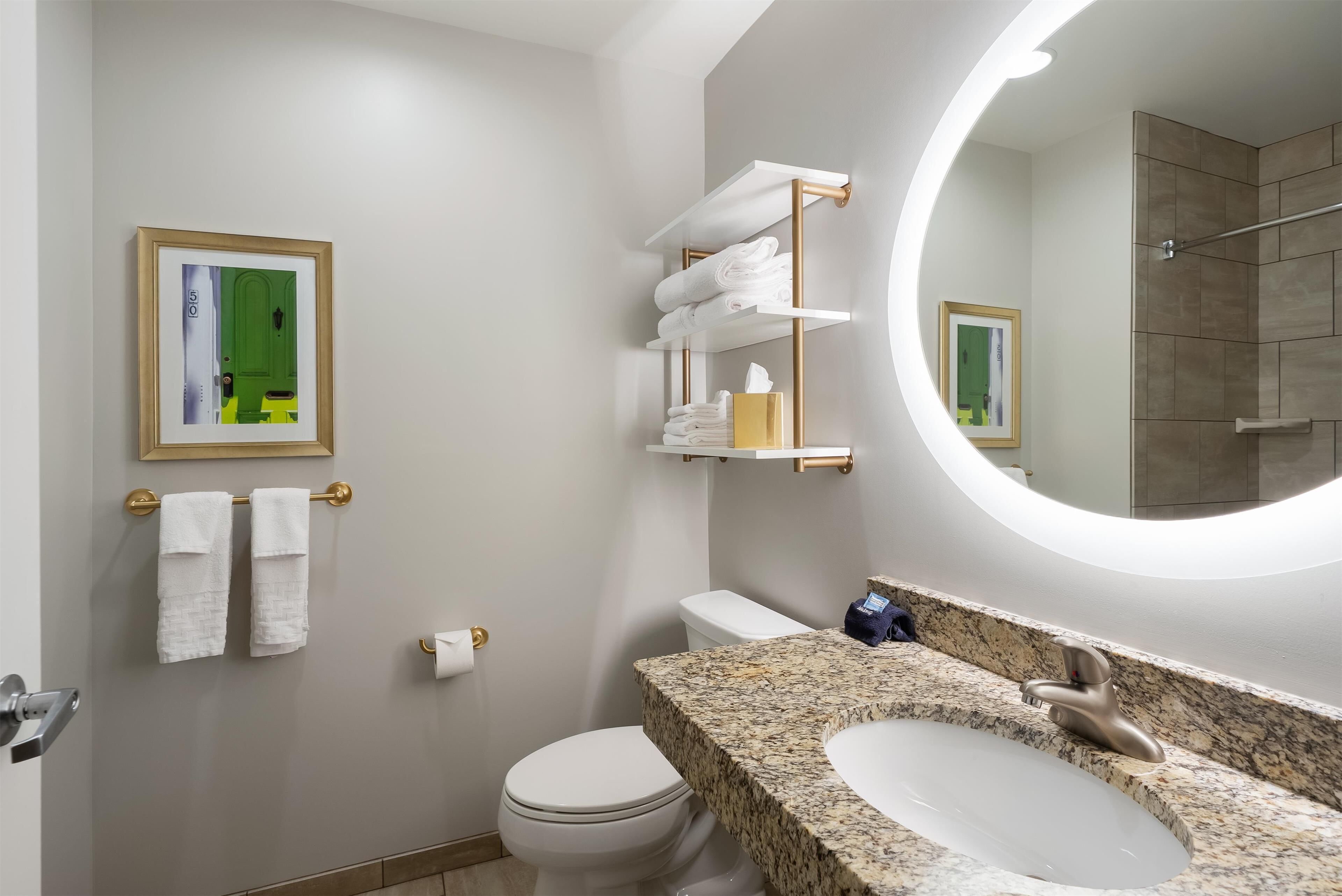Une salle de bain moderne équipée de toilettes, d’un lavabo et d’un porte-serviettes.